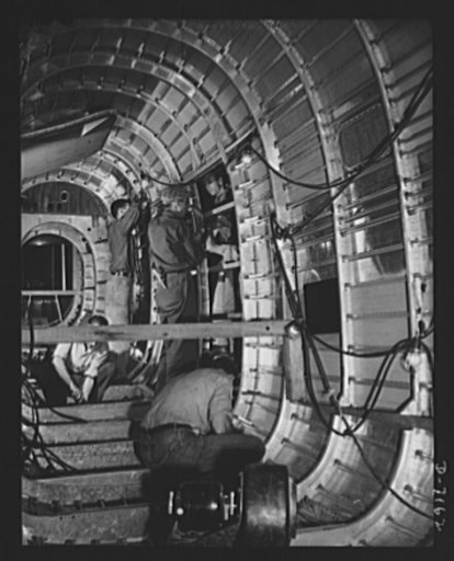 Production. B-24 bombers and C-87 transports. The cargo door of a consolidated transport plane is fitted into a tail fuselage opening at a Western aircraft plant. This new transport, an adaptation of the B-24 bomber, is known as C-87, and carries one of of the greatest human or cargo loads of any pl