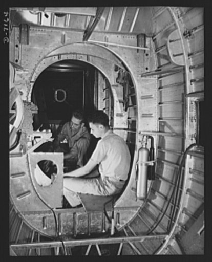 Production. B-24 bombers and C-87 transports. Structural parts of a consolidated transport plane are installed in the "tunnel" of a tail fuselage section in a Western aircraft plant. This new transport, an adaptation of the B-24 bomber, is known as C-87, and carries one of the greatest human or carg