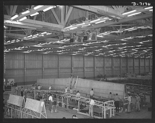 Production. B-24 bombers and C-87 transports. An assembled wing center section for a consolidated transport plane is lifted from the wing bucks by a monorail crane at a Western aircraft plant. This new transport, an adaptation of the B-24 bomber, is known as the C-87, and carries one of the greatest