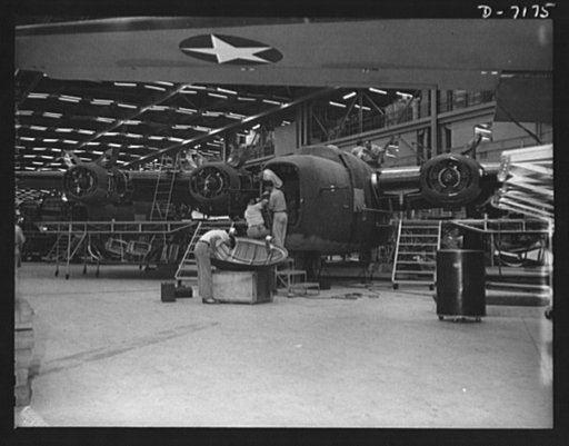 Production. B-24 bombers and C-87 transports. Another mighty warship of the air will soon be ready for "launching." A nose door is being readied for assembly on a new consolidated transport plane at the end of the assembly line of a western aircraft plant. This new transport, an adaptation of the B-