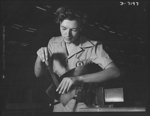 Production. B-24 bombers and C-87 transports. Nell Roy Johnson at her first job. She is filing burrs from parts to be used in making consolidated transport planes at a Western plant. This transport ship is adapted from the B-24 bomber, and carries one of the greatest human or cargo loads of any plan