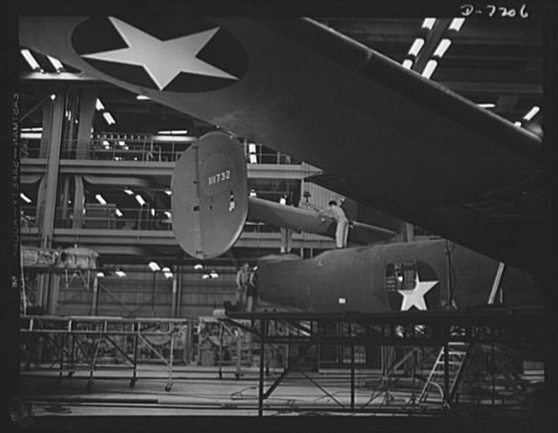 Production. B-24 bombers and C-87 transports. The empennage section of a new consolidated transport plane is lowered for installation in the assembly line of a big Western aircraft plant, at which B-24 bombers are also made. This new transport carries one of the greatest human or cargo loads of any 