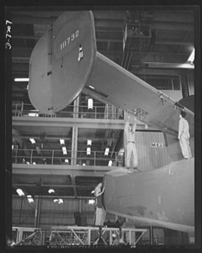 Production. B-24 bombers and C-87 transports. The empennage section of a new consolidated transport plane is lowered for installation in the assembly line of a big Western aircraft plant, at which B-24 bombers are also made. This new transport carries one of the greatest human or cargo loads of any 