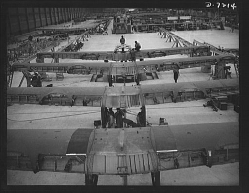 Production. B-24 bombers and C-87 transports. Wing center section for a B-24 bomber and C-87 transports ready for mating with fuselages on the assembly line. Both the bombers and the transport ships are capable of operation at high altitudes and over great ranges. The bomber proved itself an excelle