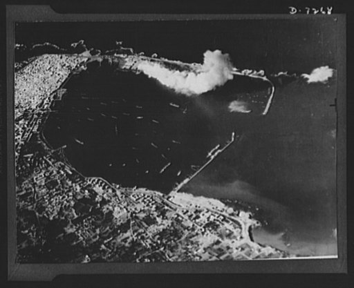 U.S. Air Force bombs Tripoli. Clouds of smoke tell the story of the successful raid by U.S. Army Air Force bombers on the Spanish mole at Tripoli. Their objective was only the mole and not ships in the harbor. This third picture in a series was taken as the bomber group finished its mission