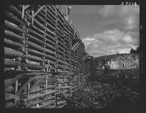 Tennessee Valley Authority. Construction of Douglas Dam. A log cofferdam at TVA's new Douglas Dam on the French Broad River. This dam will be 161 feet high and 1,682 feet long, with a 31,600 acre reservoir area extending forty-three miles upstream. With a useful storage capacity of approximately 1,3