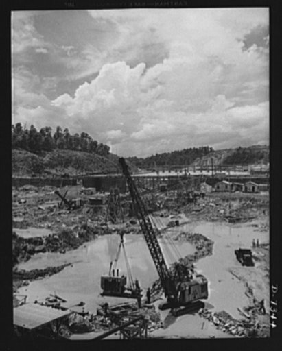 Tennessee Valley Authority. Construction of Douglas Dam.  Inside the cofferdam of TVA's new Douglas Dam on the French Broad River. This dam will be 161 feet high and 1,682 feet long with a 31,600 acre reservoir area extending forty-three miles upstream. With a useful storage capacity of approximatel