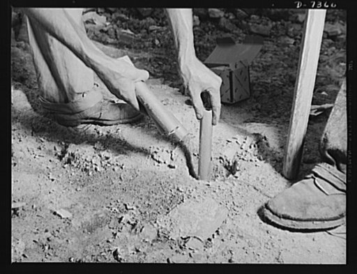 Tennessee Valley Authority. Construction of Douglas Dam. Placing a dynamite charge in a blast hole in bedrock at the site of TVA's new Douglas Dam on the French Broad River. This dam will be 161 feet high and 1,682 feet long, with a 31,600 acre reservoir area extending forty-three miles upstream. Wi