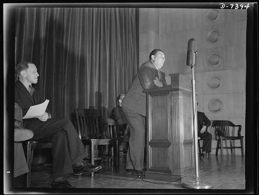 Henderson rally. Leon Henderson, Administrator, Office of Price Administration (standing) first meeting of OPA training program for price control, December 1, 1942. Auditorium, Social Security Building, Washington, D.C.