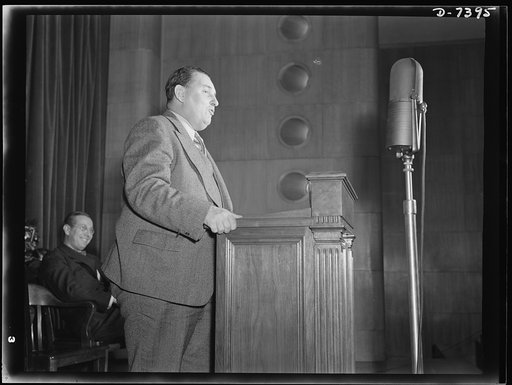 Henderson rally. Leon Henderson, Administrator, Office of Price Administration (standing) first meeting of OPA training program for price control, December 1, 1942. Auditorium, Social Security Building, Washington, D.C.