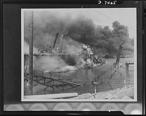 Pearl Harbor bombing. USS Shaw. Hit by three bombs which exploded her forward magazine, the 1,500 ton destroyer Shaw lies a twisted mass of wreckage in the heavily-bombed floating drydock YFD-2. Note the bow of the Shaw lying on its side in the foreground. Part of the drydock, at right, is under wat