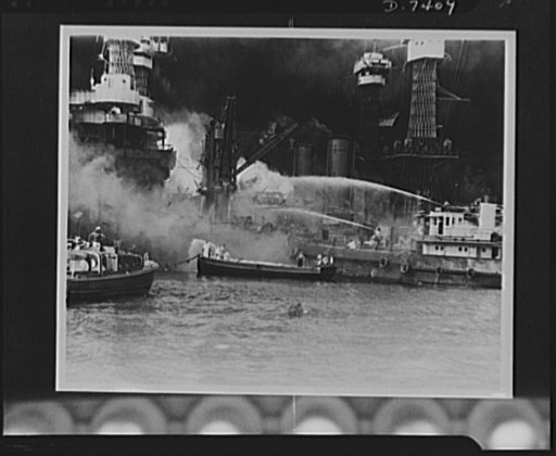 Pearl Harbor bombing. USS West Virginia a flame. Disregarding the dangerous possibilities of explosions, U.S. sailors man their boats at the side of the burning battleship, USS West Virginia, to better fight the flames started by Japanese torpedoes and bombs. Note the national colors flying against 