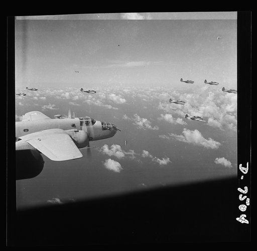 American wings over Africa. A B-25 medium bomber (foreground) is escorted by a group of A-20 light bombers serving as fighter ships over the North African desert. Their objective was an advance Axis headquarters