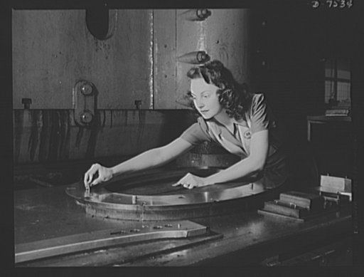 Production. Airplane manufacture, general. A woman employee in the hydraulic press department of North American Aviation, Incorporated, at Inglewood, California, places a sheet metal part on a Masonite die prior to moving it under the press. The 3,000 ton press takes only about ten seconds to do the