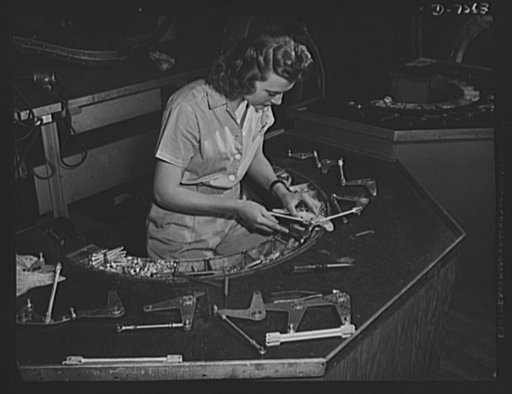 Production. Airplane manufacture, general. This woman employee at North American's Inglewood, California, plant, assembles control brackets for bomber and fighter planes. All parts are arranged conveniently in the semi-circle. This plant produces the battle-tested B-25 ("Billy Mitchell") bomber, use