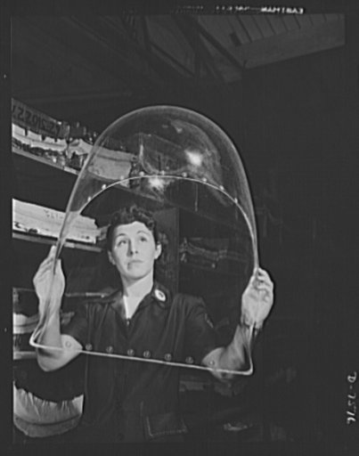 Production. Airplane manufacture, general. A woman employee in the enclosures department of North American Aviation's Inglewood, California, plant, inspects a tail cone for flaws before it moves to the assembly department. This plant produces the battle tested B-25 ("Billy Mitchell") bomber, used in