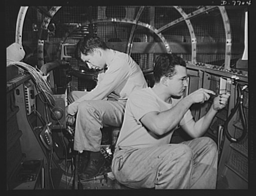Production. B-25 "Billy Mitchell" bombers. In the bombardier's compartment of a B-25 bomber, North American employees assemble the electrical system as the section moves down the long conveyor line at Inglewood, California, In addition to the battle-tested B-25 "Billy Mitchell" bomber, used in Gener
