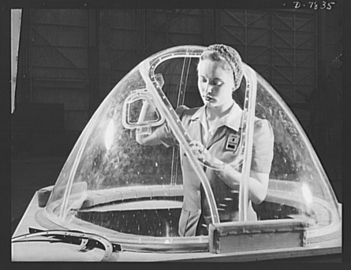 Production. B-17F heavy bombers. This girl in a glass house is putting finishing touches on the bombardier nose section of a B-17F heavy bomber. She's one of many capable women workers in the Long Beach, California, plant of the Douglas Aircraft Company. Better known as the "Flying Fortress," the B-