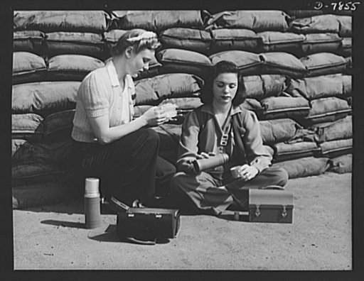 Production. Airplane maufacture, general. Lunchtime brings a few minutes of rest for these women workers of the assembly line at Douglas Aircraft Company's Long Beach, California, plant. Sand bags for protection against air raids form the background. Most important are the many types of aircraft mad