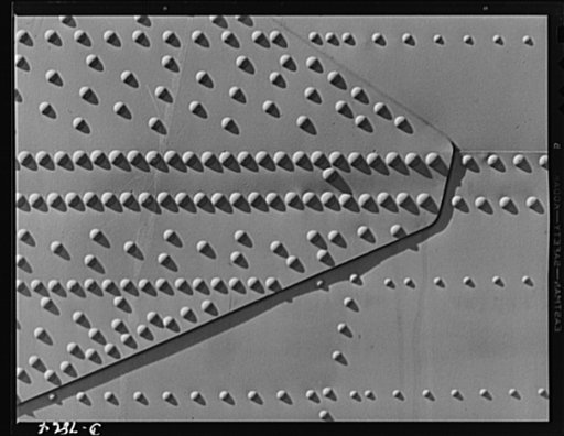 Production. Airplane maufacture, general. Why our warplanes hold together through the years of steady use, rough landings and anti-aircraft fire. These rivets cover but a small part of the surface of a mighty bomber produced at the Long Beach, California, plant of Douglas Aircraft Company. Most impo