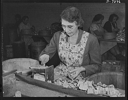 Empty collapsible tubes: a tin mine for war industry. Mrs. Madge Lewis, widow and ex-sales lady, tests old tooth paste and other tubes for metal content in the Newark, New Jersey reclamation plant of the Tin Salvage Institute. This test on an electric iron helps to identify tin and lead tubes from c