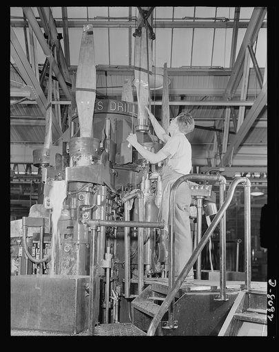 Production. Airplane propellers. Hamilton propeller blades for our warships of the air are placed into a Barnes multiple drill by Frank Krupczak at a Hartford, Connecticut, plant. This machine performs the precise boring operations required before fitting to spiders in sets of two or three