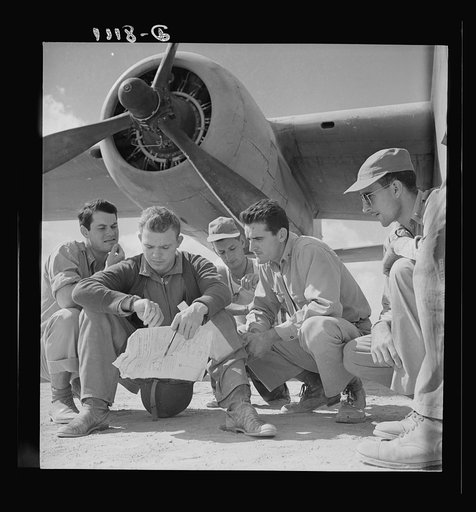U.S. desert airmen check bombing plans. The crew of an U.S. Army Air Force B-25 bomber check their flight plans at a desert air base before taking off to bomb advance Axis position. They are (left to right) Lieutenant Bob Hill, Clear Lake, Iowa, bombardier; Lieutenant Bill Brytan, Denton, Texas, pil