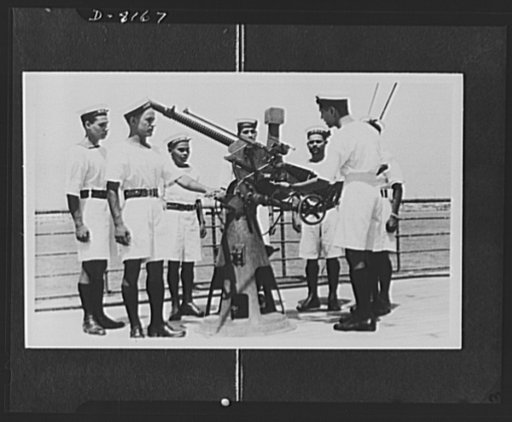 Indian troops in East Africa. A series of photos taken on board a vessel of the Royal Indian Navy on active service in Eastern waters. Captured Italian equipment proves that they have been in action. Gunnery instruction is given to the men with a captured Italian Breda gun