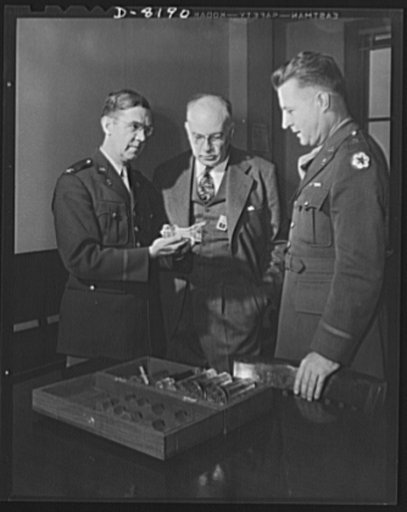 Conservation. Glass gauges replacing steel. Colonel H.B. Hambleton, Chief of Army Ordnance's Gage Section explains the virtues of a glass plug gauge to Mr. Thornton Lewis and Brigadier General H.F. Safford (left to right).  Glass gauges are lighter and cheaper than steel, permit greater visibility i