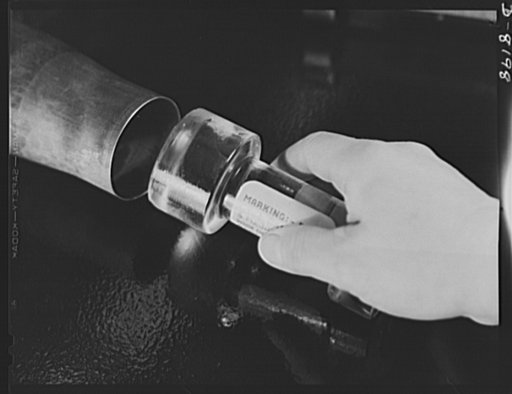 Conservation. Glass gauges replacing steel. Checking an inside diameter of a cartridge case with one of the glass gauges which replace steel gauges at the Frankford Arsenal. Glass gauges are lighter and cheaper than steel, permit greater visibility in inspection, are not as much affected by room tem