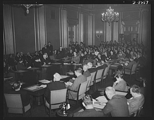 War Labor Board anthracite hearing. Labor members, seated at the left of conference table, and employer members, seated at the right, hear testimony of striking coal miners at the hearing on the anthracite strike before the National War Labor Board, January 15, 1943