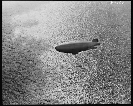 U.S. Navy starts out on patrol duty. Soaring over the Atlantic Ocean, a U.S. Navy blimp is silhouetted against the sparkle of waves. These lighter-than-air craft are used for anti-submarine patrols