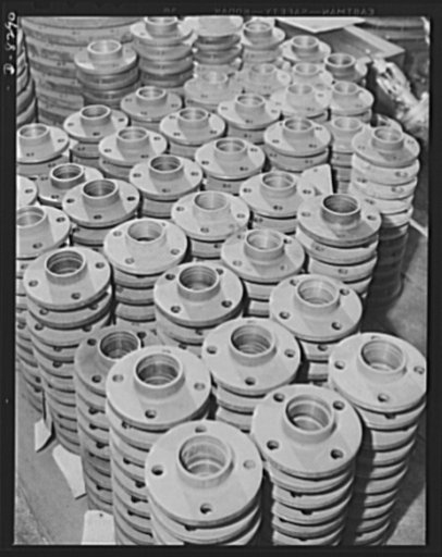 Shipbuilding. Pipes and fittings. Steel pipe flanges in the pipe shop at the Wilmington, California, yard of the California Shipbuilding Corporation. The Booker T. Washington, recently launched at this yard, is one of the many freighters the company has built since Pearl Harbor