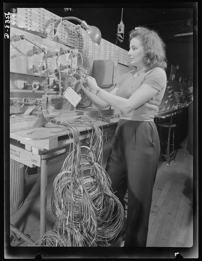 Production. B-17F heavy bomber. Checking electrical wiring assemblies for B-17F (Flying Fortress) bombers at the Boeing plant in Seattle. The Flying Fortress, a four-engine heavy bomber capable of flying at high altitudes, has performed with great credit in the South Pacific, over Germany and elsewh