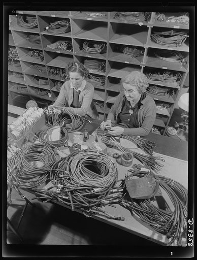 Production. B-17F heavy bomber. Checking electrical wiring assemblies for B-17F (Flying Fortress) bombers at the Boeing plant in Seattle. The Flying Fortress, a four-engine heavy bomber capable of flying at high altitudes, has performed with great credit in the South Pacific, over Germany and elsewh