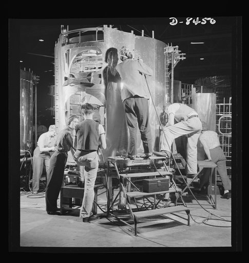 Production. B-17 heavy bomber. A crew of fast, expert workers at the Boeing plant in Seattle rivet a fuselage section for a new B-17F (Flying Fortress) bomber. Working on the section in the vertical position saves much valuable floor space. The Flying Fortress has performed with great credit in the 