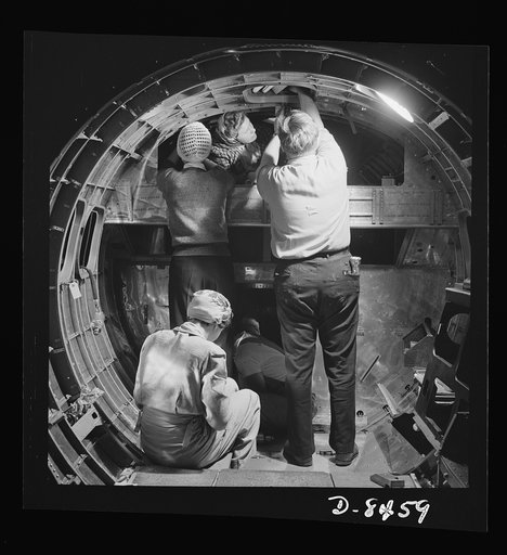Production. B-17 heavy bomber. A skilled team of men and women workers at the Boeing plant in Seattle complete assembly and fitting operations on the interior of a fuselage section for a new B-17F (Flying Fortress) bomber. About half of the workers at the Boeing plant are women. The Flying Fortress 