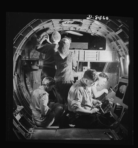 Production. B-17 heavy bomber. A skilled team of men and women workers at the Boeing plant in Seattle complete assembly and fitting operations on the interior of a fuselage section for a new B-17F (Flying Fortress) bomber. About half of the workers at the Boeing plant are women. The Flying Fortress 