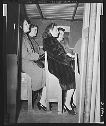 War wagon trailer. It's better than standing! Government girls accustomed to crowded buses in the nation's capitol try out the "stand-sit" seat--a space saving feature of the new war wagon trailer