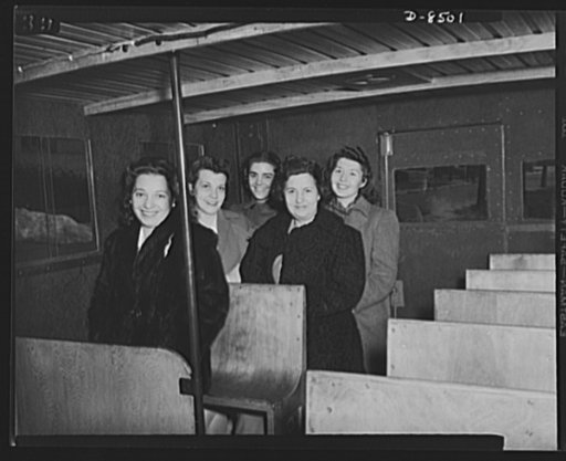 War wagon trailer. It's better than standing! Government girls accustomed to crowded buses in the nation's capitol try out the "stand-sit" seat--a space saving feature of the new war wagon trailer