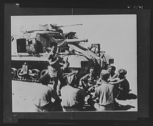 British tank men study U.S. tanks between battle in Egypt. British tank crews in Egypt train for the use of tanks arriving for the U.S.A. Experts on the U.S. machine give impromptu lessons, then the men climb aboard and examine every detail themselves. A gunner giving a talk on the 75mm gun