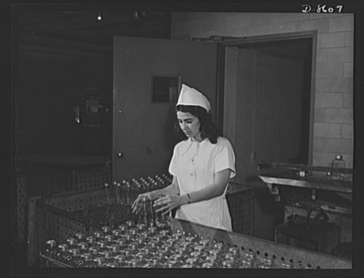 Production. Blood transfusion bottles. Loading blood transfusion bottles into trucks, prior to sterilization. One of the many women workers performing war work at Baxter Laboratories, Glenview, Illinois, is Patricia Marinillo, whose husband is in the Navy