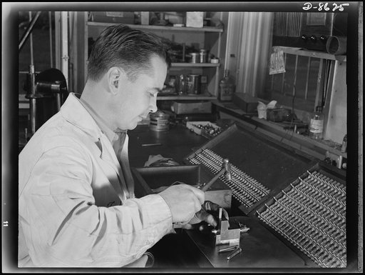 Production. Blood transfusion bottles. Employed by a local subcontractor for Baxter Laboratories Inc., Glenview, Illinois, Theodore G. Coffin, a former auto mechanic numbers the barrels of the valves for blood transfusion bottles prepared by Baxter's for use in blood banks