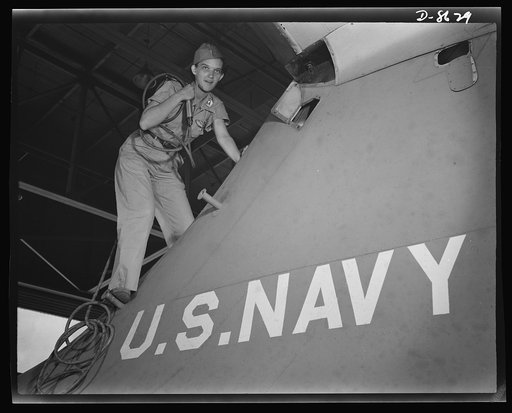Naval air base, Corpus Christi, Texas. Mounting a navy flying ship at the naval air base in Corpus Christi, Texas, a former department store girl, is one of many women who are taking over jobs to release men for military service. She is a civil service crowler in the assembly and repair department a