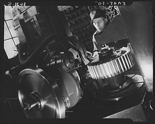 Conversion. Farm implements to cargo winches. Making a vernier caliper measurement of a tooth on a cargo winch gear in a converted Midwest farm implement plant. The hobbing machine used in this operation formerly cut bull gears for plow tractors