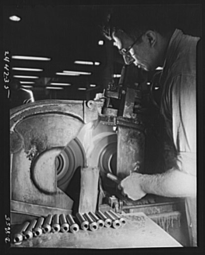 Conversion. Farm implements to gun parts. Prior to conversion to the production of military equipment, a centerless grinder was used by a Midwest farm implement manufacturer for grinding bearing pins for bell cranks of harvesting machines. This machine is now used in the production of 37 mm. shells