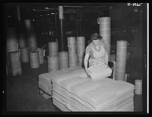 Printing war ration book 2. Jessie Calabase stacks the sheets containing four coupon books as they come from the collator ready to be transferred to the cutting department