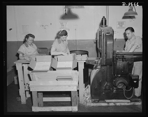 Printing war ration book 2. Glued sheets containing four ration books pass through the cutting machine and come out into single ration books. Weelan Reilly feeds the cutter as Ida Stuart, left, and Isabel Small, check the books and pack them in cardboard containers