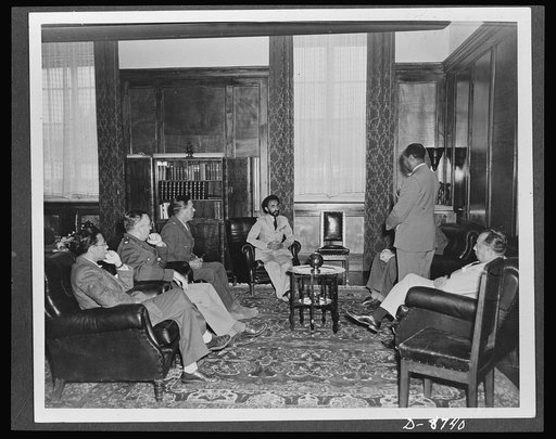 American military delegation calling on Haile Selassie. In conference with the American delegation. Left to right: F. N. Plangin, Office of War Information (OWI); Lieutenant Colonel Robert M. Baughey; Colonel Edwin Clark; His Majesty, Haile Sellassie, Emperor of Ethiopia; Taffarra Worq (standing), a