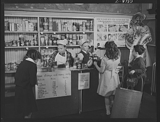 Preparation for point rationing. Buying canned and bottled foods with war ration book two becomes real to pupils in this model store set up in a classroom in the Park View Elementary School, Washington, D.C. Referring to the posted list, pupils learn practical arithmetic when they figure both prices
